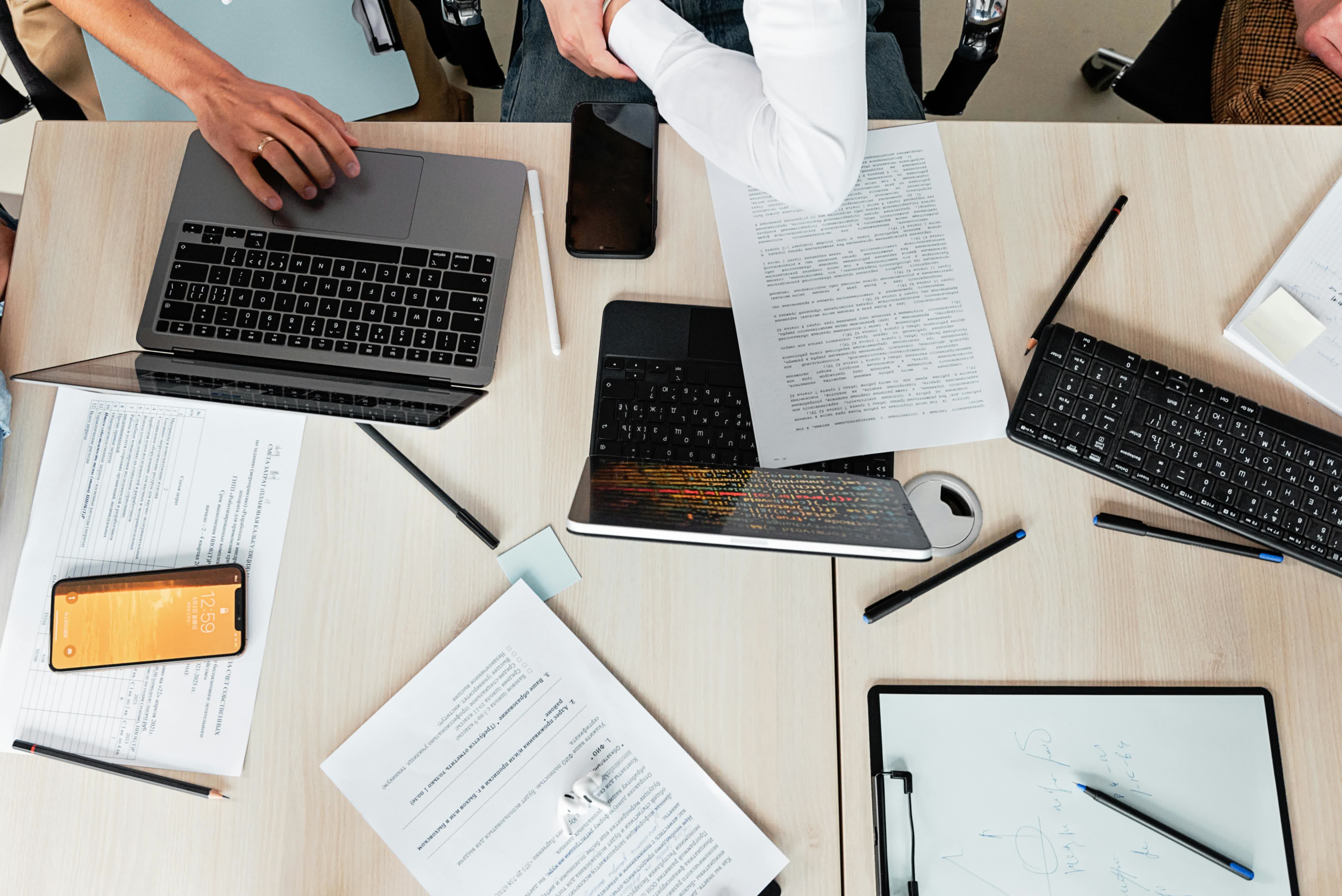 Top view of a work desk with laptop, documents and smartphone