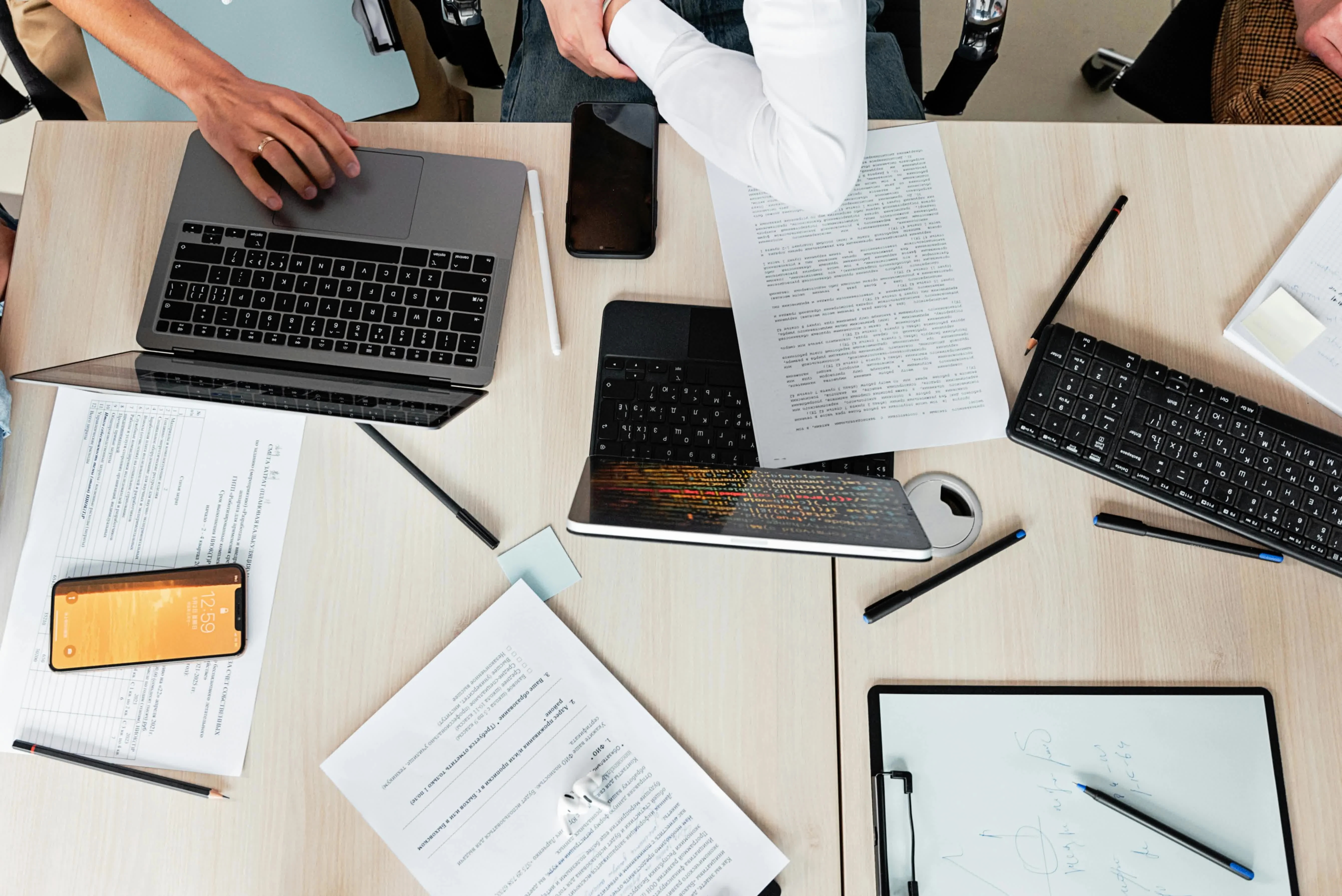 Top view of a work desk with laptop, documents and smartphone